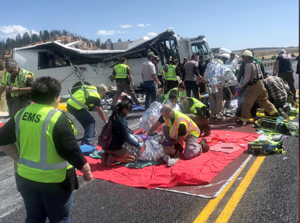 In this photo released by the Garfield County Sheriff's Office, Emergency Medical Services personnel assist victims of a bus crash near Bryce Canyon National Park in southern Utah, Friday, Sept. 20, 2019. (Sheriff Danny Perkins/Garfield County Sheriff's Office via AP)