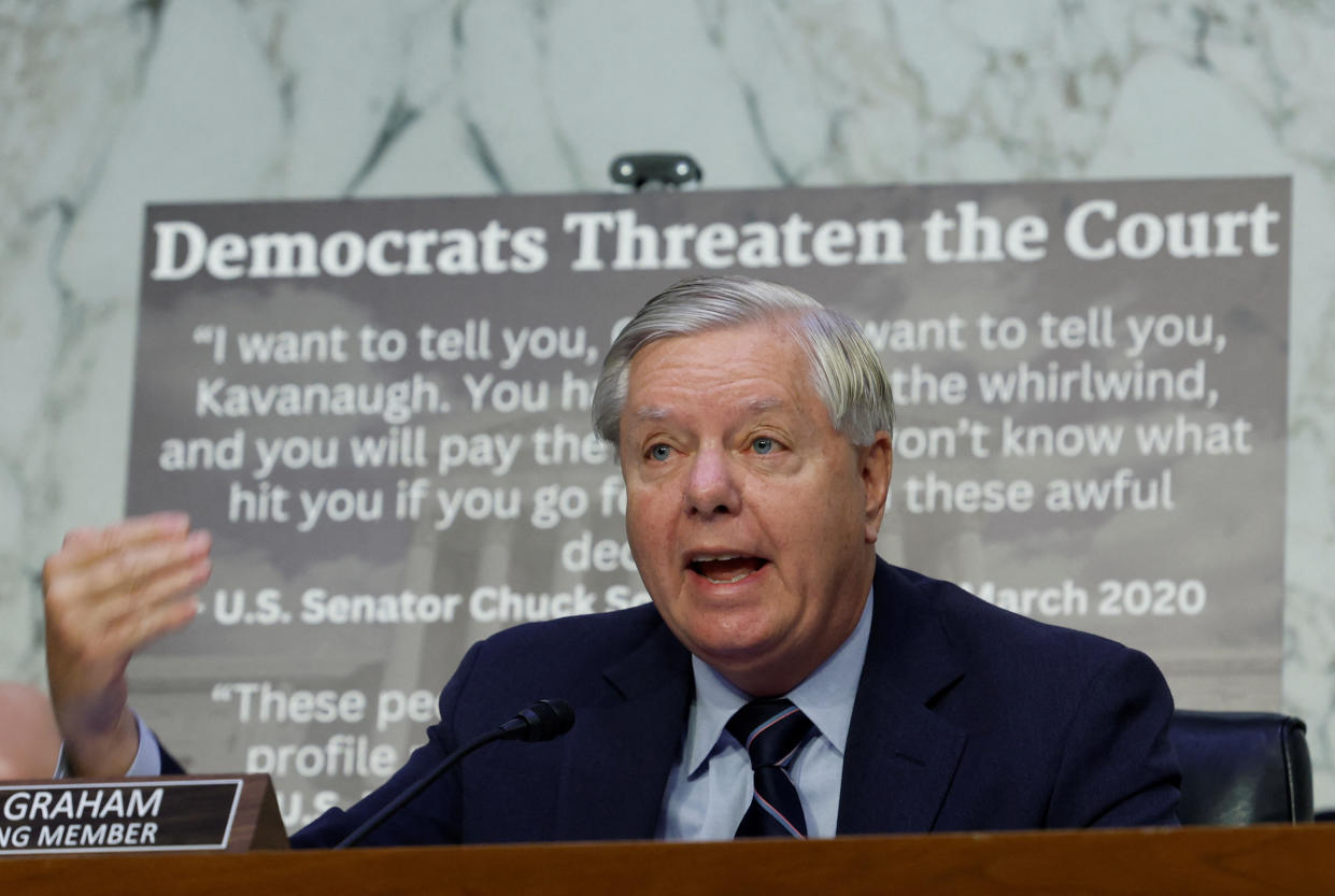 Sen. Lindsey Graham speaks in front of a poster headlined: Democrats Threaten the Court, with a March 2020 quote from Sen. Chuck Schumer, D-N.Y., commenting on Justice Brett Kavanaugh.