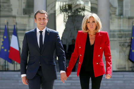 FILE PHOTO - French President Emmanuel Macron and his wife Brigitte Macron walk in the Elysee Palace courtyard July 6, 2017, to welcome guests, prior to the launching of a program to enhance the diagnosis and treatment of autism, in Paris, France. Picture taken July 6, 2017. REUTERS/Thibault Camus/Pool/File Photo