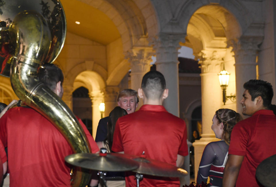 President Donald Trump talks with members of the Florida Atlantic University Marching Band after they performed during a Super Bowl party at the Trump International Golf Club in West Palm Beach, Fla., Sunday, Feb. 2, 2020. (AP Photo/Susan Walsh)