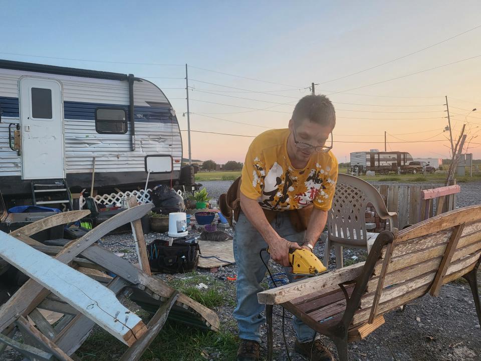 Ida Shelter resident Nathaniel Fournier cuts wood outside of his state-provided camper as hurricane season begins, June 1.