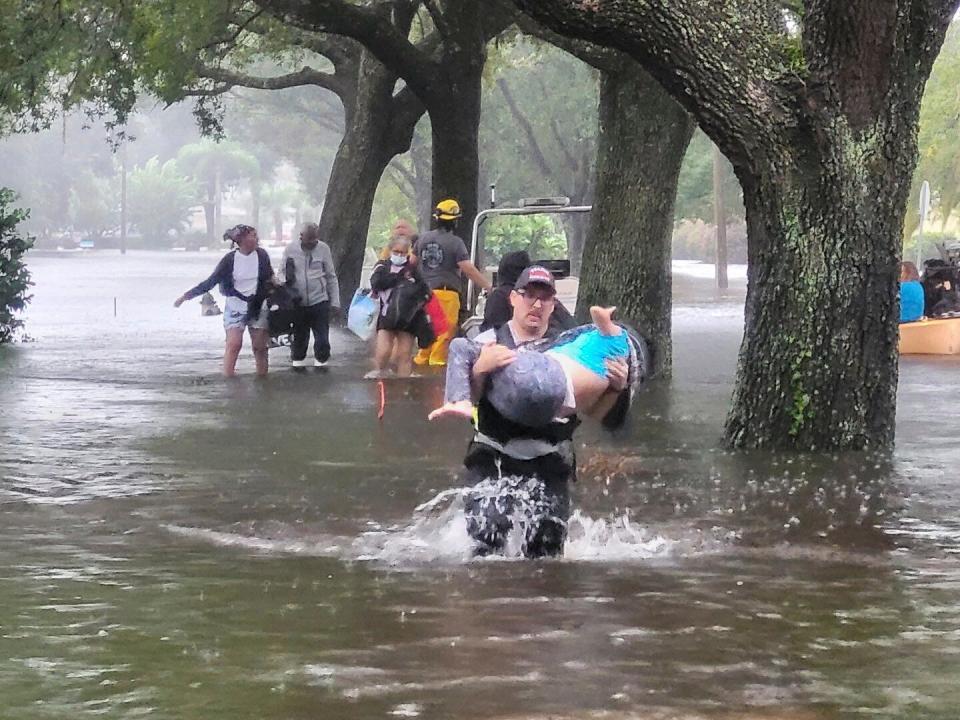 In this photo provided by Orange County Fire Rescue's Public Information Office, firefighters in Orange County, Fla., help people stranded by Hurricane Ian early Thursday, Sept. 29, 2022. Ian marched across central Florida on Thursday as a tropical storm after battering the state’s southwest coast, dropping heavy rains that caused flooding and led to inland rescues and evacuations.