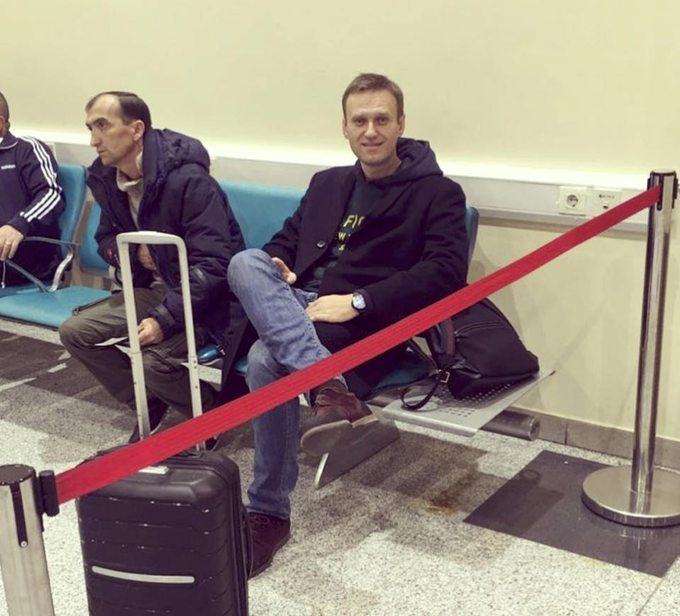 In this photo released by Anti-corruption Foundation Press Service, Russian anti-corruption crusader Alexei Navalny sits behind a red ribbon at Domodedovo international airport outside Moscow, Russia, Tuesday, Nov. 13, 2018. Navalny was stopped at the border Tuesday and barred from leaving Russia as he was about to travel to a court hearing at the European Court for Human Rights in France. (Anti-corruption Foundation press service via AP)