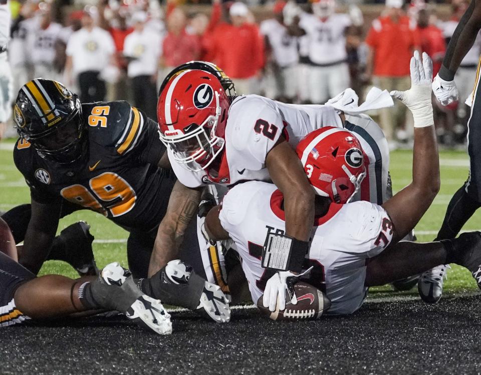 Oct 1, 2022; Columbia, Missouri; Georgia Bulldogs running back Kendall Milton (2) scores against Missouri Tigers defensive back Jaylon Carlies (1) and linebacker Dameon Wilson (10) during the second half at Faurot Field at Memorial Stadium. Denny Medley-USA TODAY Sports