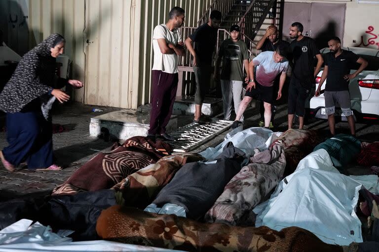 En esta fotografía tomada frente a la morgue del hospital Mártires de Al Aqsa en Deir al-Balah, en la Franja de Gaza, el jueves 6 de junio de 2024, varios palestinos lloran por sus familiares muertos por un bombardeo israelí contra una escuela de la ONU en el campamento de refugiados de Nusseirat. (AP Foto/Abdel Kareem Hana)