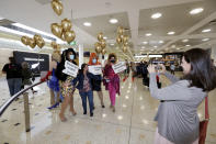 A passenger from New Zealand, center, poses with drag queens as they welcome her at Sydney Airport in Sydney, Australia, Monday, April 19, 2021, as the much-anticipated travel bubble between Australia and New Zealand opens. (AP Photo/Rick Rycroft)