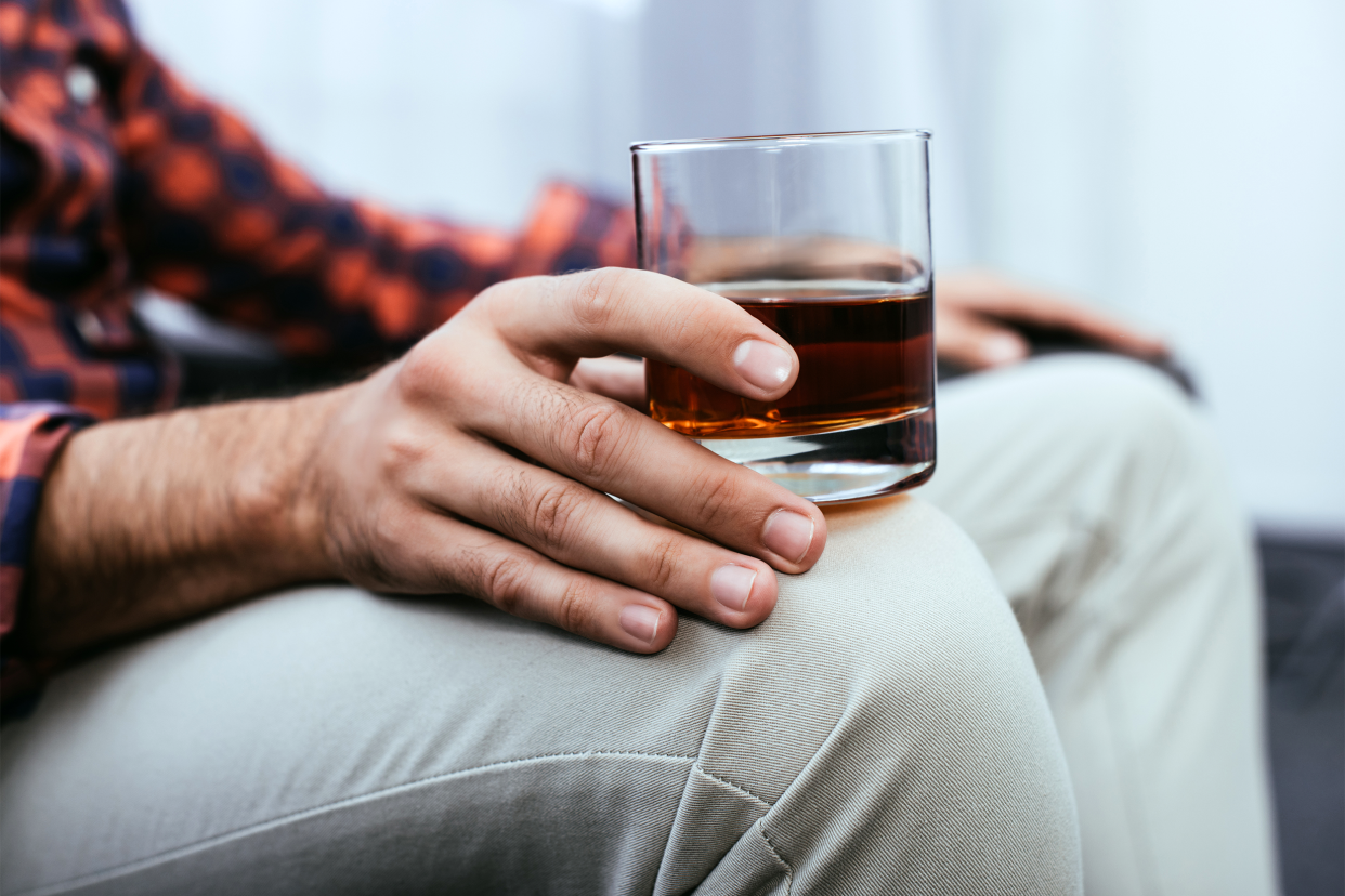 Man sitting with a glass of alcohol