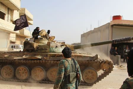 Members of al Qaeda's Nusra Front ride on a tank as they head towards their positions during an offensive to take control of the northwestern city of Ariha from forces loyal to Syria's President Bashar al-Assad, in Idlib province May 28, 2015. REUTERS/Ammar Abdullah