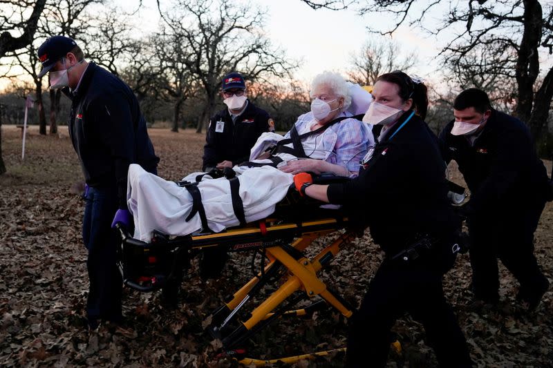 Paramedics prepare to transport an 87-year-old woman who had been exposed to the COVID-19 in Meeker