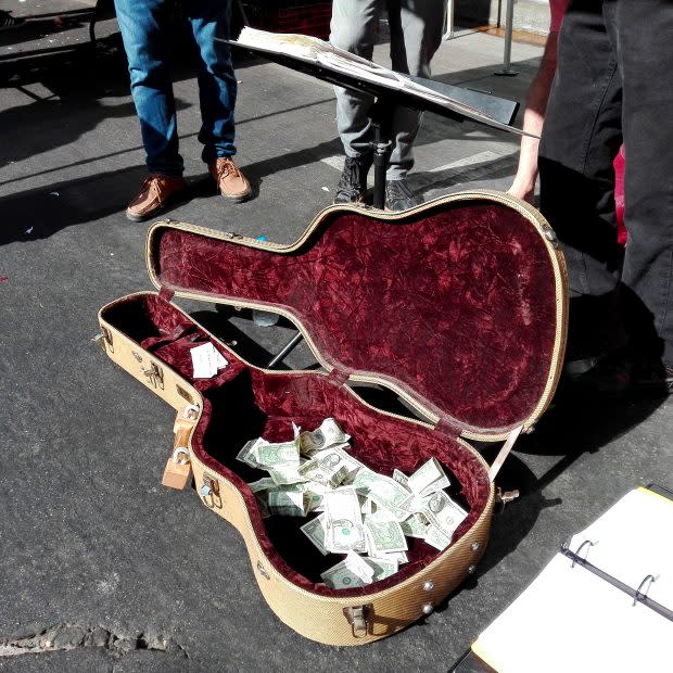 Der mit Dollarnoten gefüllte Gitarrenkoffer eines Straßenmusikers