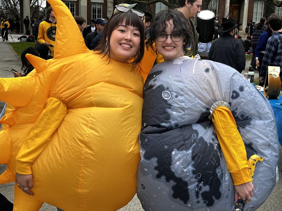 The sun, University of Rochester student Alexana Dubois, joined with her friend, the moon, Rianna Ehrenreich, at the Eastman Quadrangle before Monday's eclipse.