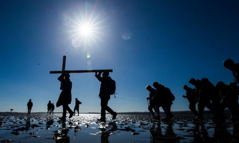 Pilgrims carry a cross.