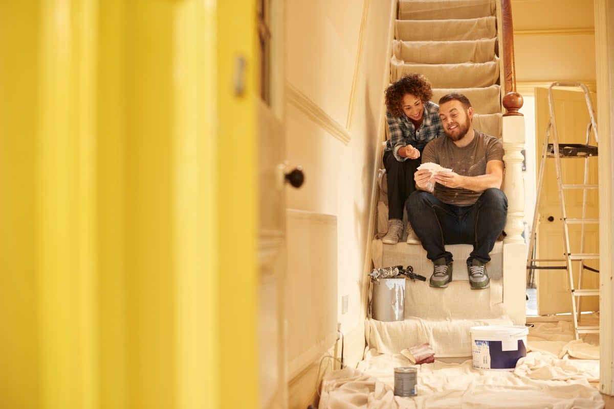 Couple sitting on stairs in middle of home repair