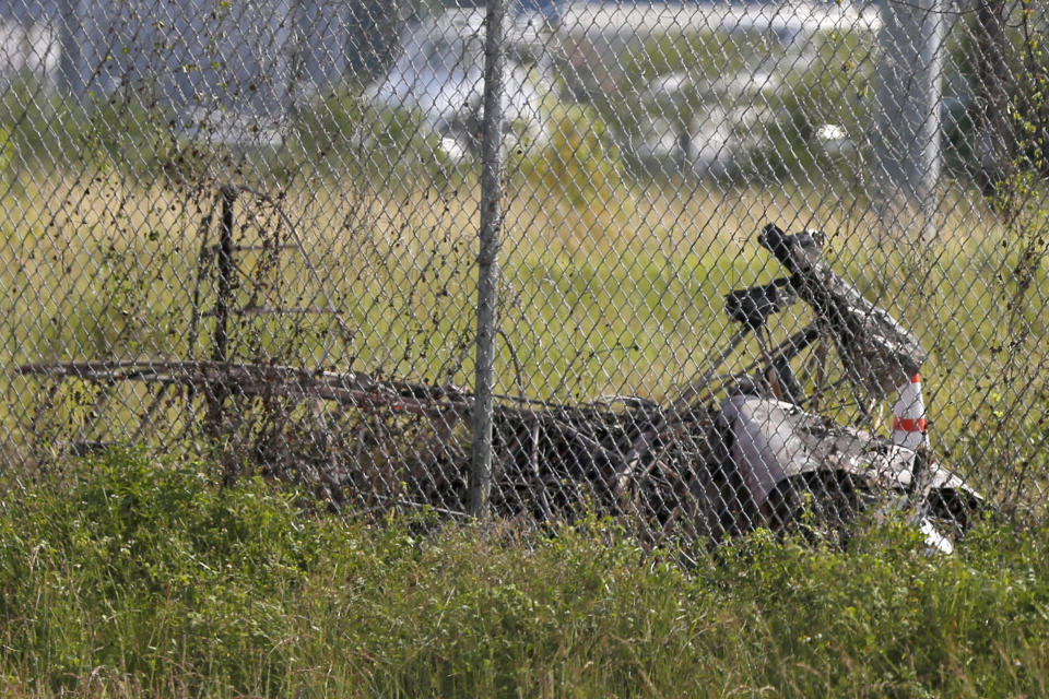 The charred wreckage of a private plane is seen in a field near the Industrial Canal and New Orleans Lakefront airport.