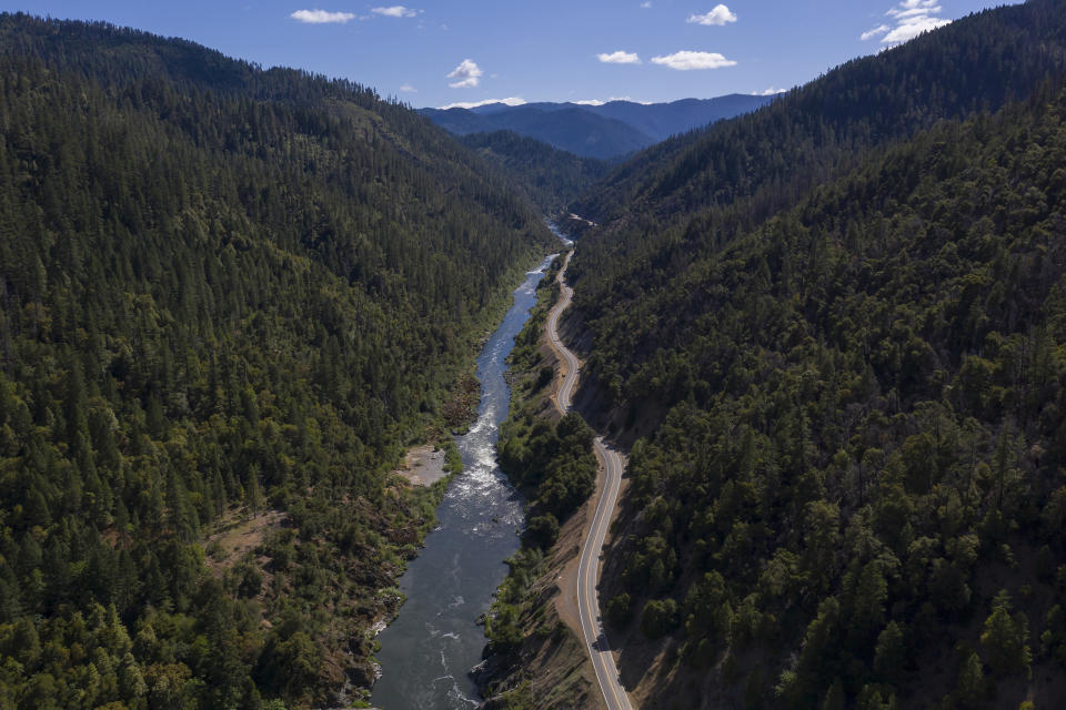 FILE - The Klamath River winds runs along state Highway 96 on June 7, 2021, near Happy Camp, Calif. Work has begun on removing four dams along the Klamath River, the largest dam removal project in history. All the dams are scheduled to come down by the end of 2024. (AP Photo/Nathan Howard, File)