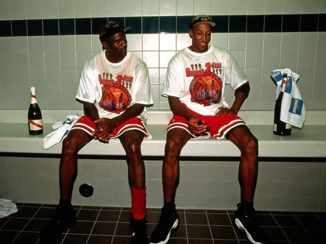 <p>Nathaniel S. Butler/NBAE/Getty</p> Michael Jordan #23 and Scottie Pippen #33 of the Chicago Bulls celebrate in the locker room after winning the 1998 NBA Championship