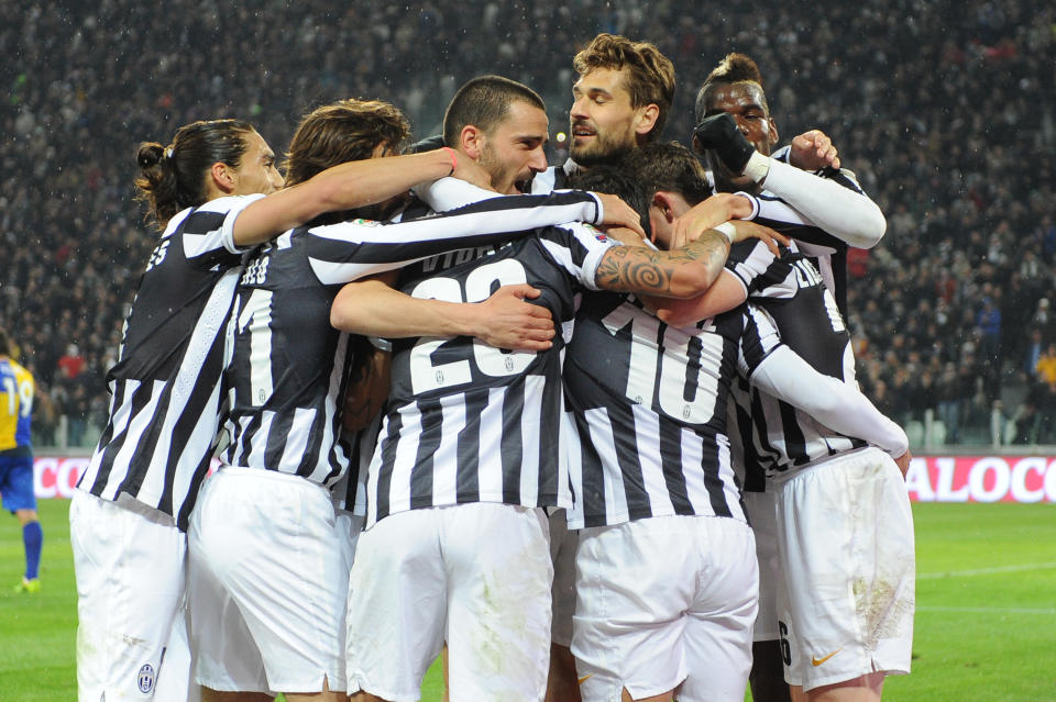 Juventus players hug their teammate Carlos Tevez, hidden at center, after he scored during a Serie A soccer match between Juventus and Parma at the Juventus stadium, in Turin, Italy, Wednesday, March 26, 2014. (AP Photo/Massimo Pinca)