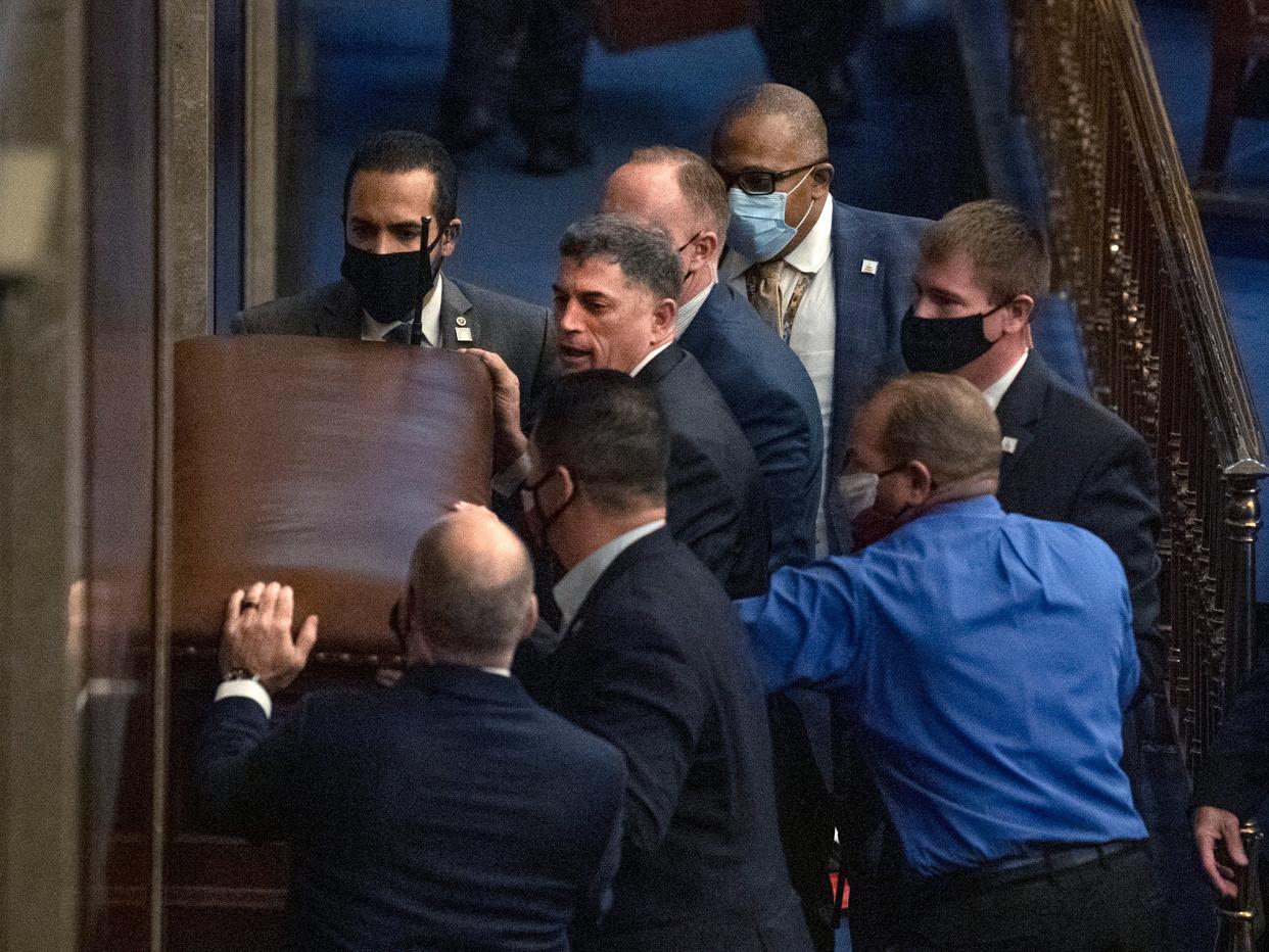 <p>Picture showing Andrew Clyde (second-in, left) barricading the House chamber doors on 6 January</p> (Roll Call, Inc via Getty)