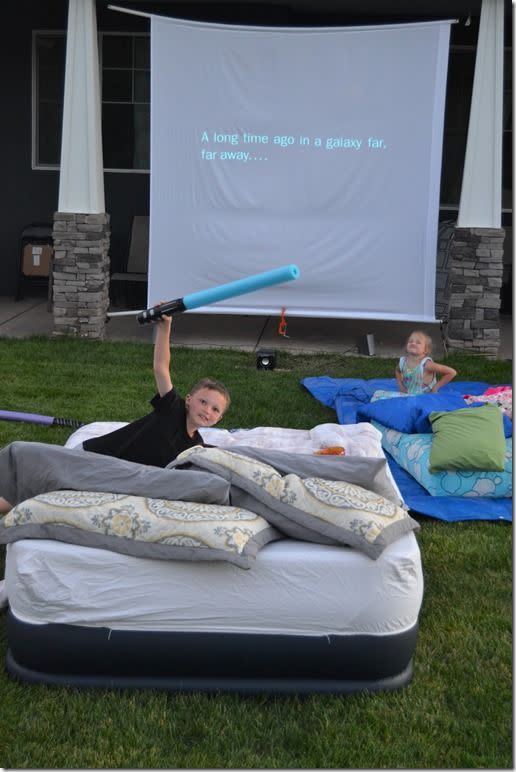 summer activities son and daughter sitting outside with a movie screen in the background