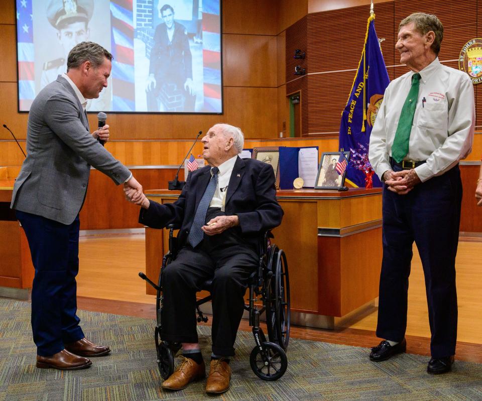 Ed Trester, 95, watches as Bill Pruitt, 102, shakes hands with U.S. Congressman Mike Waltz after he presented them with Congressional Gold Medals for their service in the U.S. Merchant Marine during World War II at a ceremony at the St. Johns County Administration building in St. Augustine on Thursday, June 30, 2022.