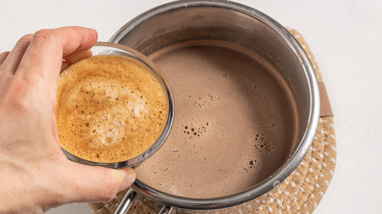 Adding espresso to a saucepan with hot chocolate