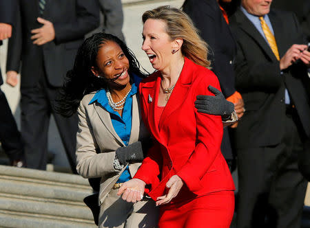 Freshman members of the incoming U.S. 114th Congress Mia Love (R-UT) (L) and Barbara Comstock (R-VA) huddle together in freezing temperatures after participating in a class photo on the steps of the U.S. Capitol in Washington in a November 18, 2014 file photo. REUTERS/Gary Cameron/Files