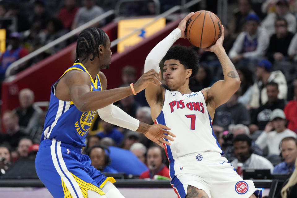 Detroit Pistons guard Killian Hayes (7) is defended by Golden State Warriors forward Jonathan Kuminga (00) during the first half of an NBA basketball game, Monday, Nov. 6, 2023, in Detroit. (AP Photo/Carlos Osorio)