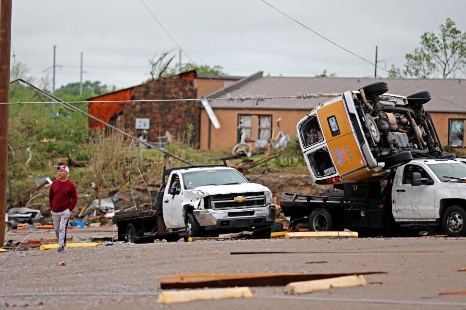 A man walks past tornado damage in Sulphur, Okla., Sunday, April 28, 2024, after severe storms hit the area the night before.