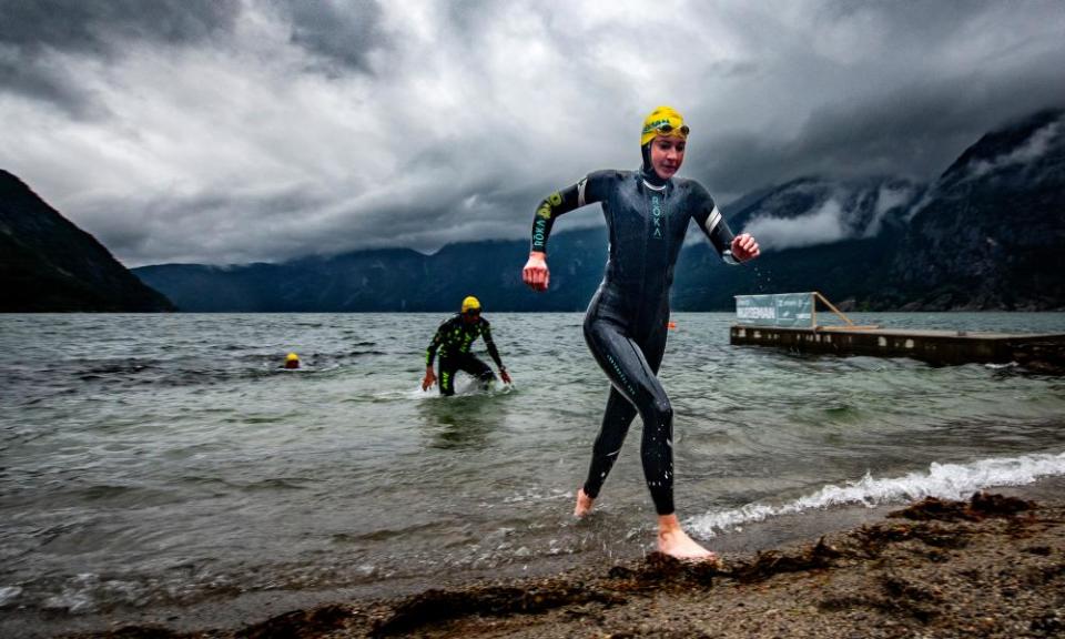 Competitors rush out of a fjord after a 2.5-mile swim in 13C water.