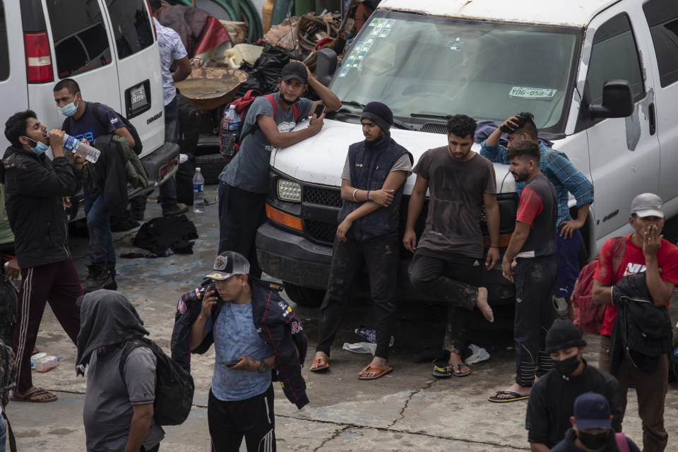 Migrants wait in the patio at the Attorney Generals Office after they were intercepted from inside cargo trailer trucks driving on the highway, in Coatzacoalcos, Veracruz state, Mexico, Friday, Nov. 19, 2021. About 500 migrants were riding in two cargo trucks when they were stopped and detained by the Criminal Investigation Agency and the National Immigration Institute, according to those two organizations. (AP Photo/Felix Marquez)