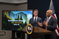 California Gov. Gavin Newsom, left, listens as Finance Director Joe Stephenshaw, right, answers a reporte'rs concerning Newsom's revised 2024-25 state budget during a news conference in Sacramento, Calif., Friday, May 10, 2024. (AP Photo/Rich Pedroncelli)