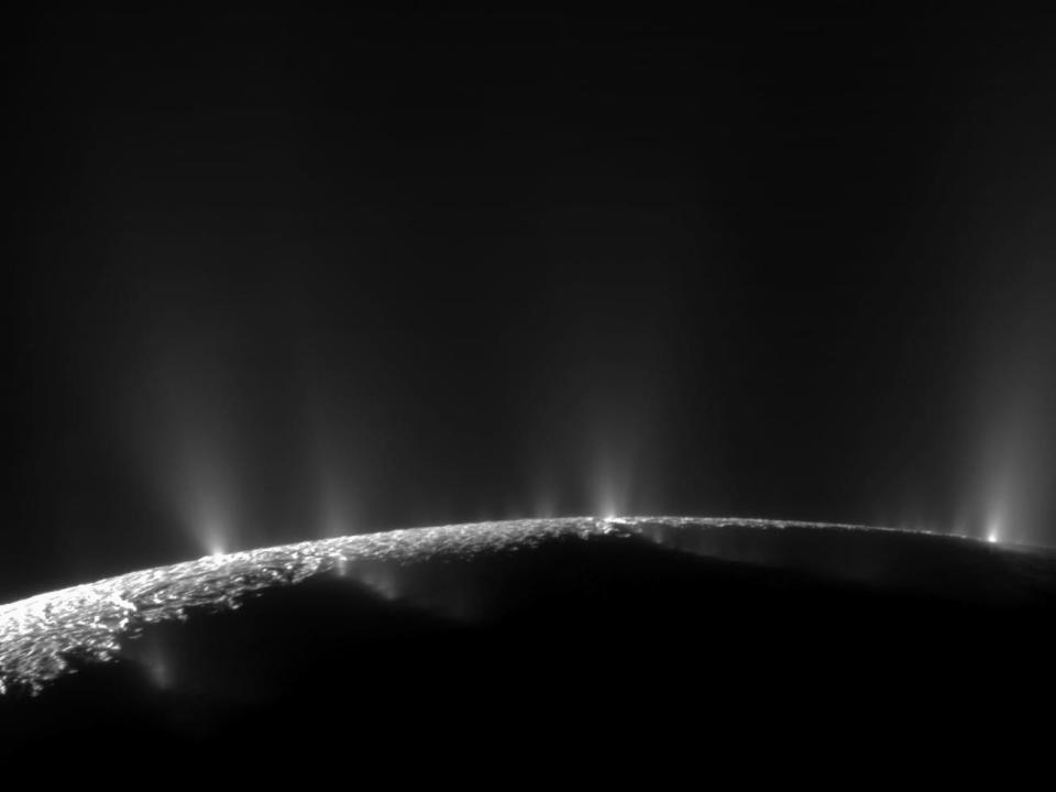 dark moon enceladus horizon with white jets shooting into space