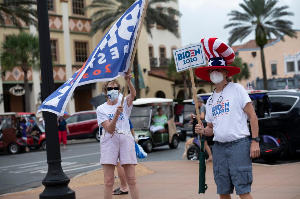 People wave signs and flags as cars drive through with the Ridin’ with Biden parade at the Spanish Springs Square in The Villages in 2020.