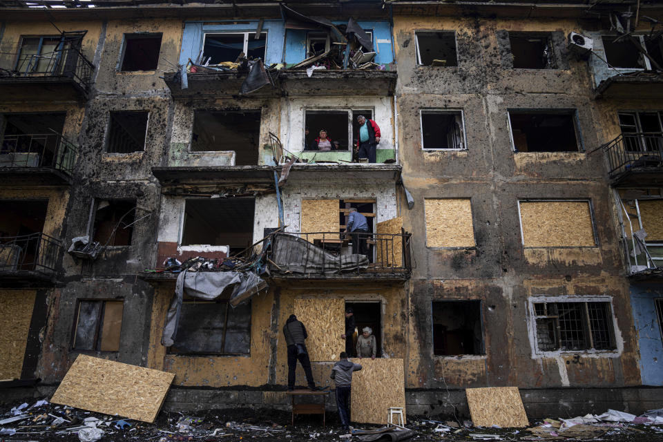 Local residents close the windows of an apartment building with plywood after Russian shelling in Dobropillya, Donetsk region, eastern Ukraine, Saturday, April 30, 2022. (AP Photo/Evgeniy Maloletka)