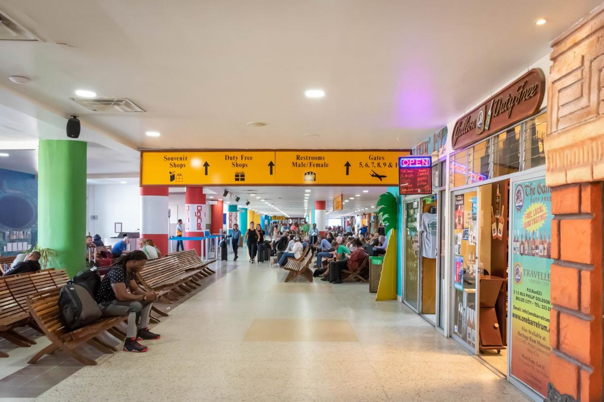 Passengers waiting for their flights inside international Philip S W Goldson Airport.