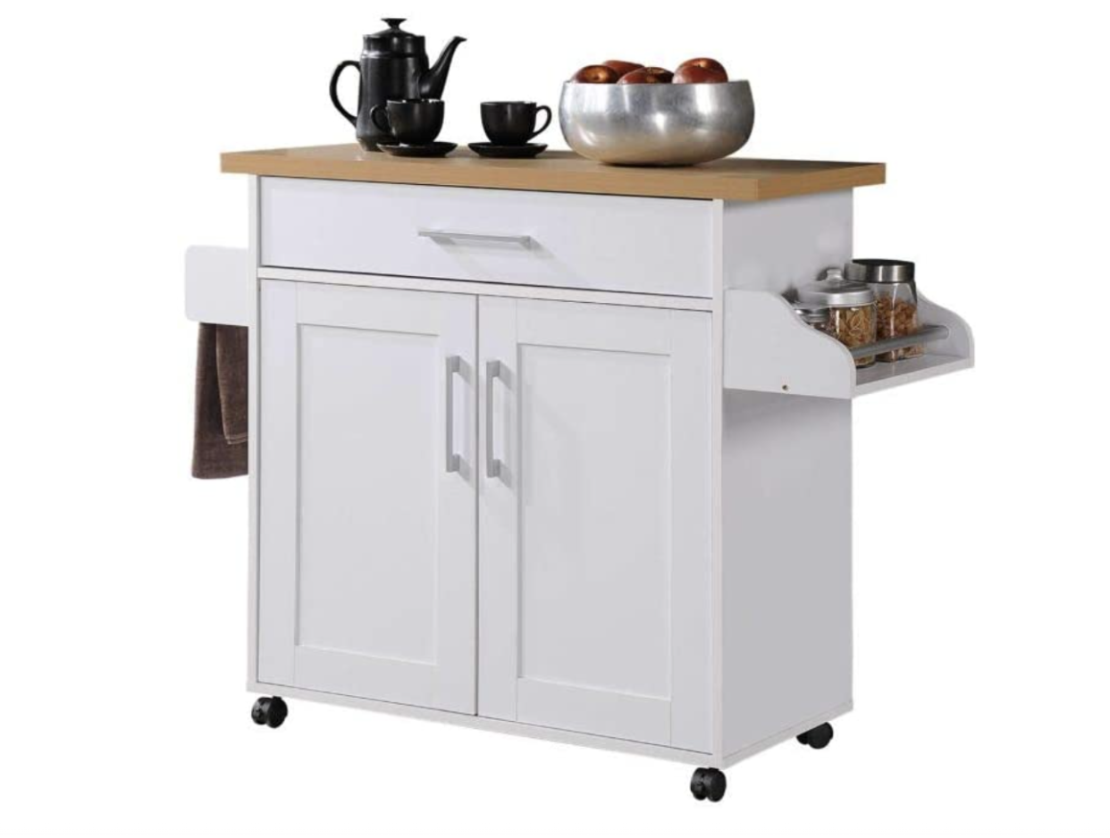 White kitchen island with wooden cutting board and spice rack.