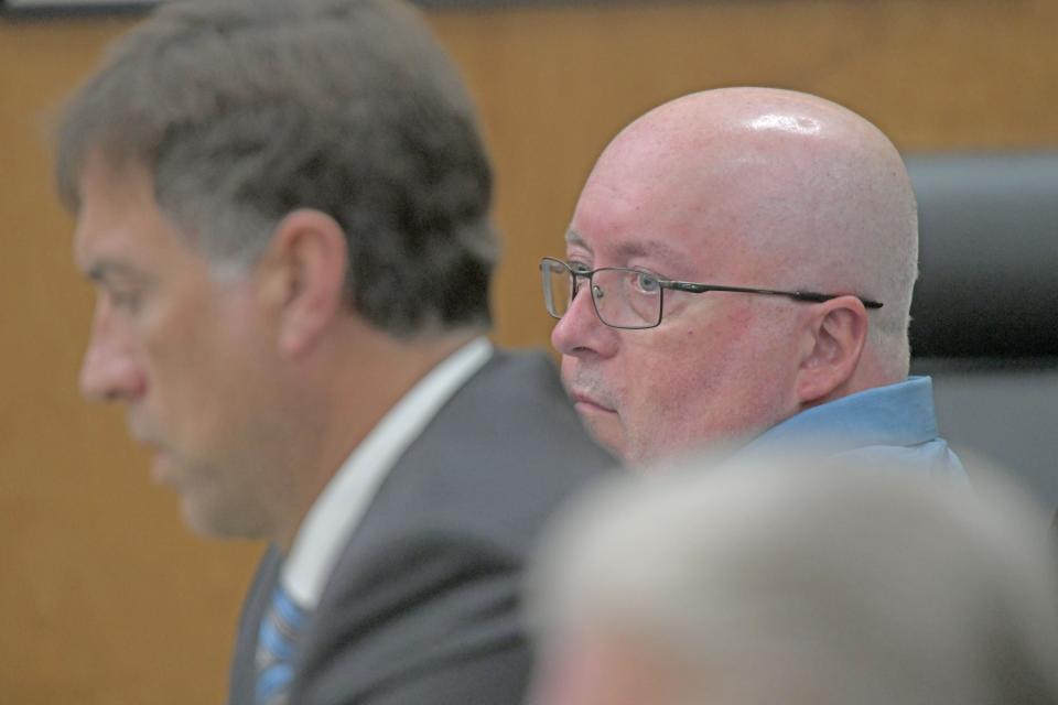 Mark Cooper listens to statements made during his trial.