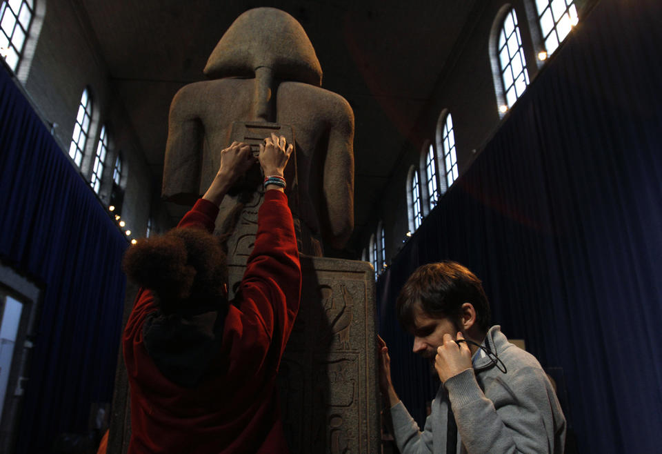 <p>Angel Ayala, left, and Austin Seraphin touch a quartzite likeness of Ramesses II at the Penn Museum in Philadelphia, Nov. 25, 2013. Ayala, 16 and blind since birth, touched ancient Egyptian artifacts at the University of Pennsylvania archaeology museum as part of a tour for the blind and visually impaired. Seraphin is also blind and helped to develop the tour. (Photo: Jacqueline Larma/AP) </p>