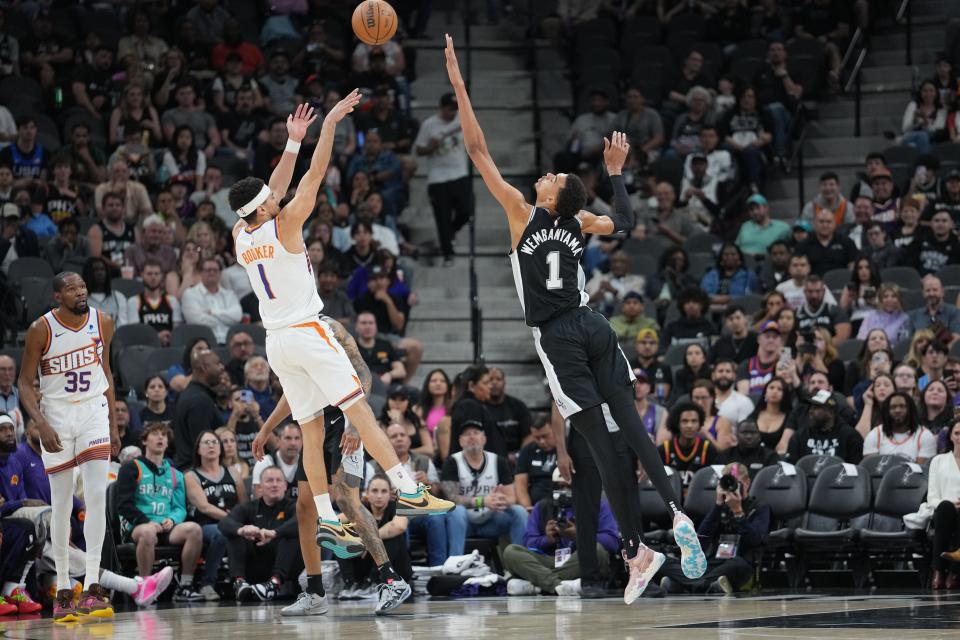 Phoenix Suns guard Devin Booker (1) shoots over San Antonio Spurs center Victor Wembanyama (1) in the first half at Frost Bank Center.