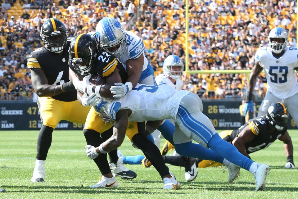 Aug 28, 2022; Pittsburgh, Pennsylvania, USA;  Pittsburgh Steelers running back Najee Harris (22) carries the ball as Detroit Lions defensive end Demetrius Taylor (62) and safety DeShon Elliott (5) defend during the first quarter at Acrisure Stadium.