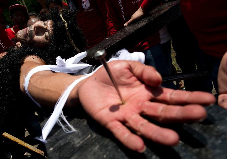 A Filipino Roman Catholic devotee is nailed to a cross during the a re-enactment of the Crucifixion of Christ during Good Friday celebrations ahead of Easter in the village of Santa Lucia, Pampanga, north of Manila, on April 18, 2014