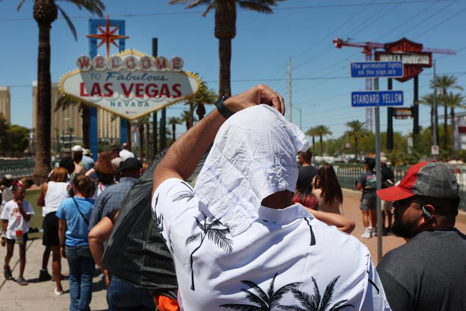Satya Soviet Patnaik shields himself from the sun while waiting in line to take a photo at the historic Welcome to Las Vegas Sign during a heat wave in Las Vegas, Nevada, on July 14, 2023. Climate scientists are sounding alarm about the impact of human-caused global warming, and warning 2023 is on track to be the warmest since records began. Global surface temperatures have increased by about 2F (1.1C) since 1880, making extreme heat more frequent. Extreme heat is the deadliest weather hazard in the United States, according to official data, with the elderly, the very young, people with mental illness and chronic diseases at highest risk. (Photo by Ronda Churchill / AFP) (Photo by RONDA CHURCHILL/AFP via Getty Images) ORIG FILE ID: 1532805637