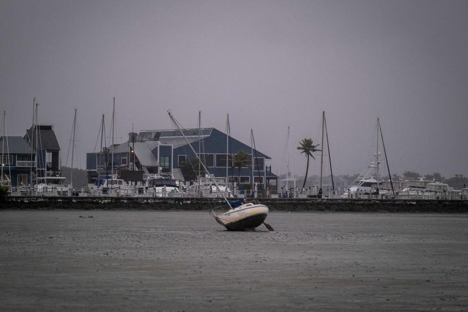 A sailboat lies askew in Charlotte Harbor in Punta Gorda, Fla.