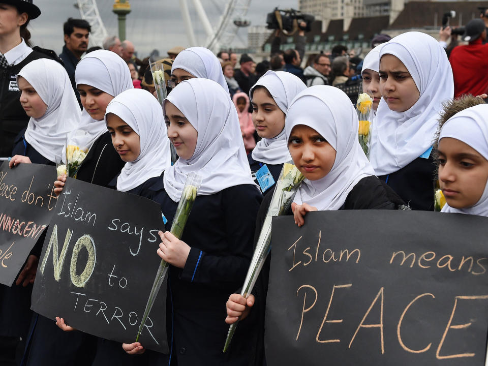 Muslim children carrying flowers join a vigil on Westminster Bridge in London on 29 March: EPA