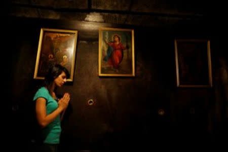 Palestinian swimmer Mary Al-Atrash, 22, who will represent Palestine at the 2016 Rio Olympics, prays at The Church of the Nativity in the West Bank town of Bethlehem June 27, 2016. REUTERS/Ammar Awad