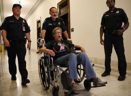 A protester is escorted by police after being arrested during a demonstration outside Senate Majority Leader Mitch McConnell's constituent office after Senate Republicans unveiled their healthcare bill on Capitol Hill in Washington, U.S., June 22, 2017. REUTERS/Kevin Lamarque