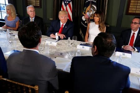 U.S. President Donald Trump (C) with first lady Melania Trump (R) meets with Secretary of Health and Human Services (HHS) Tom Price (L) to discuss opioid addiction during a briefing at Trump's golf estate in Bedminster, New Jersey, U.S., August 8, 2017. REUTERS/Jonathan Ernst