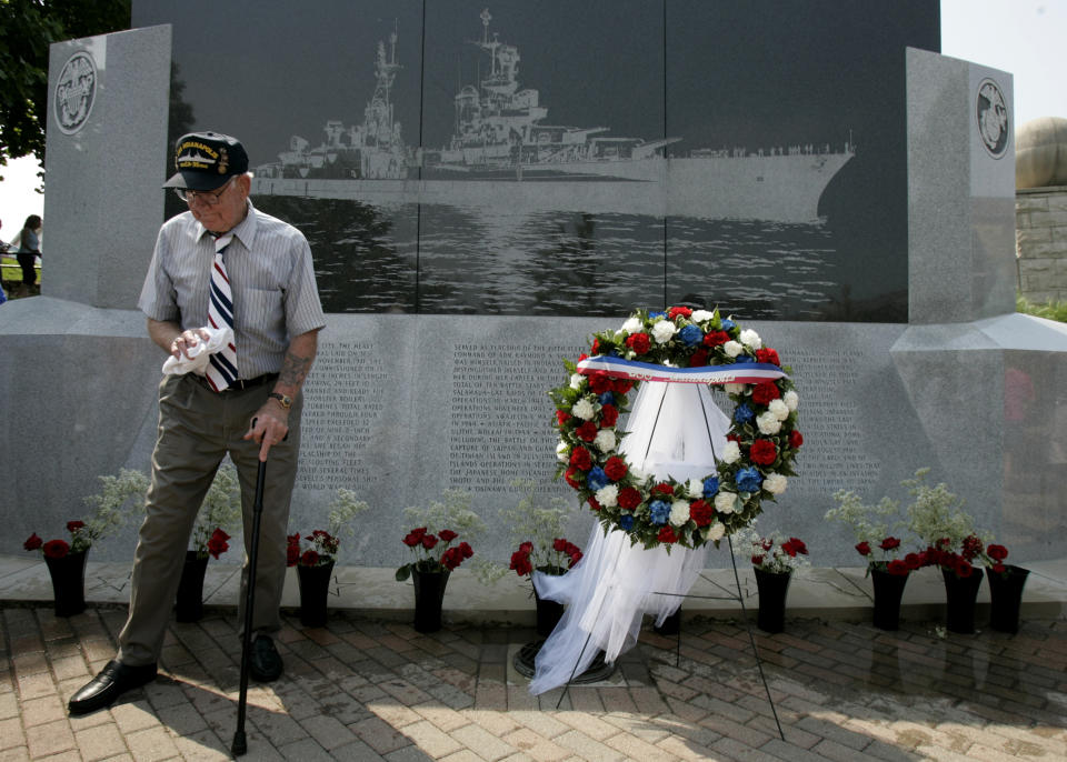 FILE - USS Indianapolis survivor Albert Morris of Akron, Ohio walks past a monument honoring fallen shipmates following a service in Indianapolis on July 24, 2005. The U.S. Navy on Friday, May 27, 2022, said it has changed the status of 13 sailors who were lost when Japanese torpedoes sank the USS Indianapolis July 30, 1945. There were only 316 survivors among the ship's crew of 1,195 sailors. About 300 went down with the ship and about 900 men were set adrift. (AP Photo/Darron Cummings, File)