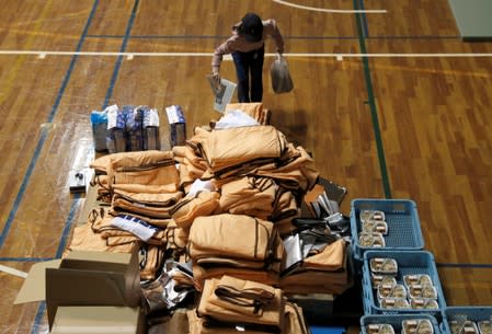 A person takes goods provided in the evacuation centre for affected by the flood after Typhoon Hagibis in Nagano