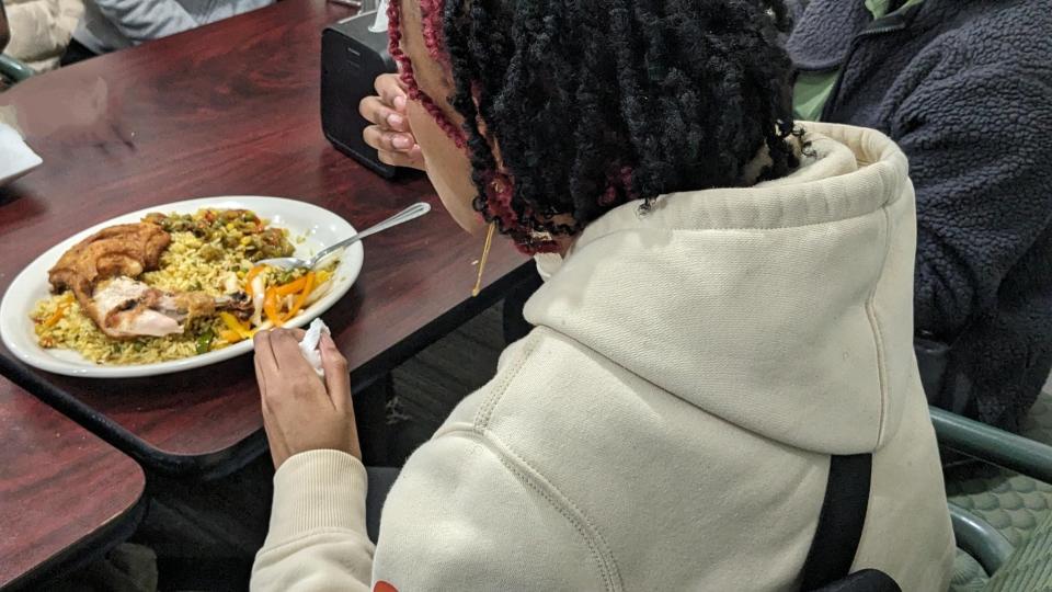 Augustana student Nasteho Abhi enjoys food at Neighborhood Market restaurant during an Augustana University Halal market shopping trip Saturday, March 9, 2024, in Sioux Falls, South Dakota.